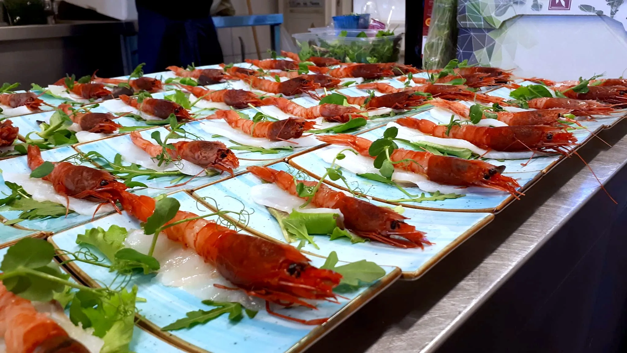 Gamberi rossi su piatti azzurri, con pesce crudo e insalatina