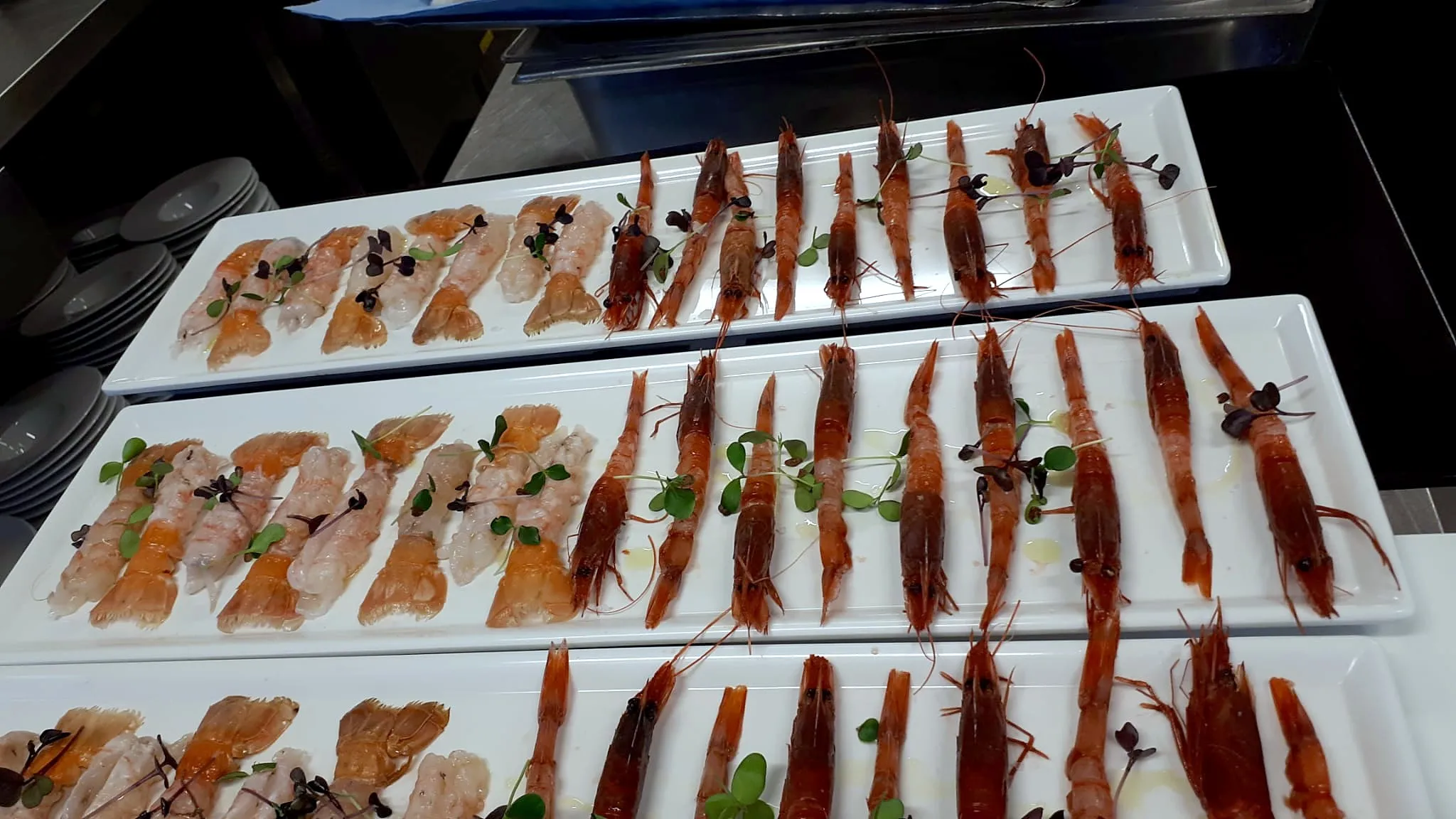 Vassoi bianchi di pesce crudo e gamberi rossi, pronti per il servizio